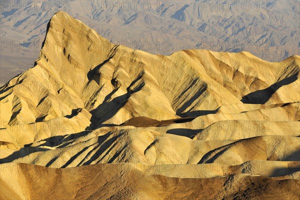 View from Zabriskie Point over the eroded rock formations of Manly Beacon discoloured by minerals