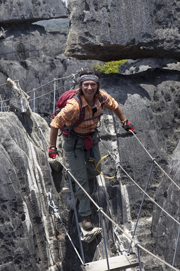 Tourist crossing a suspension bridge in the Great Tsingy de Bemaraha limestone formations