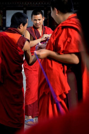 Buddhist monks producing textile trimmings
