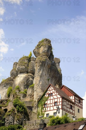 Half-timbered house next towering karst rocks