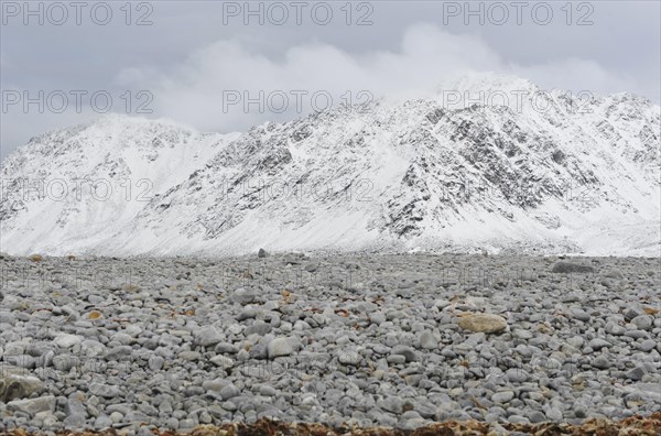 Gravel field in front of a snow-covered summit ridge