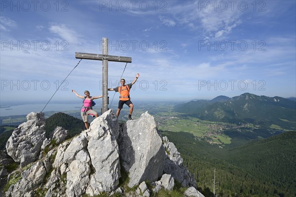 Hikers standing next to the cross on the summit of Friedenrath mountain