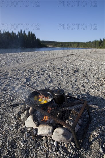 cooking / frying bacon and eggs on a camp fire
