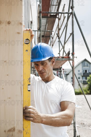 Construction manager controlling the window installation with a spirit level