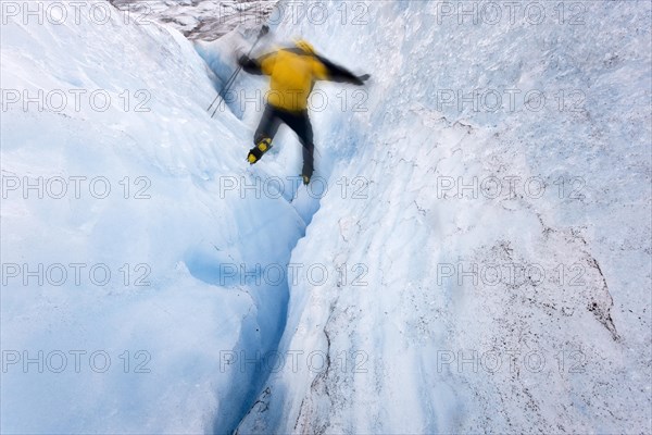 Mountaineer jumping into a small crevasse on Matanuska Glacier