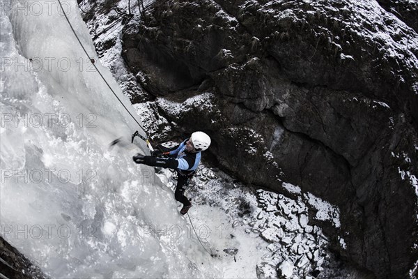 Ice climber climbing a frozen waterfall