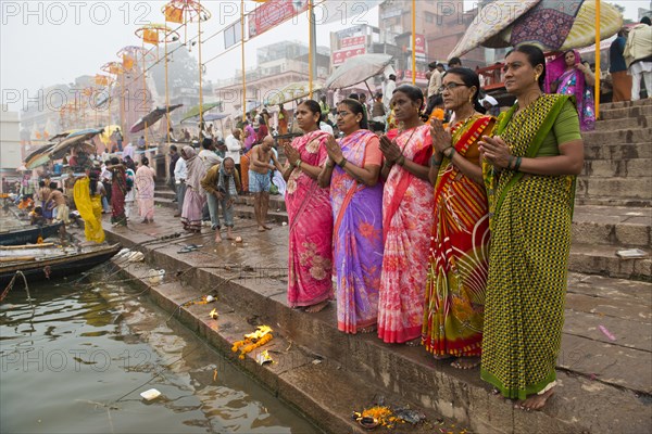 Five women in colorful saris in prayer