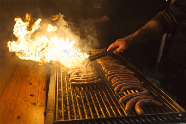 Sausages on a barbecue grill with flames