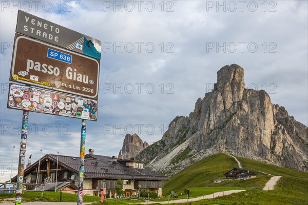Signboard and hut at Giau Pass with Gusela mountain at the back