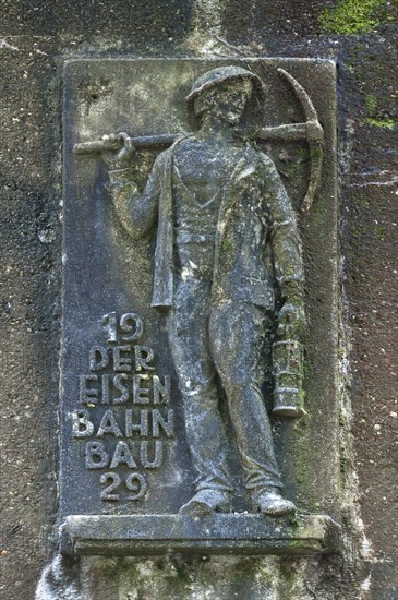 Man holding a pickaxe and a lamp