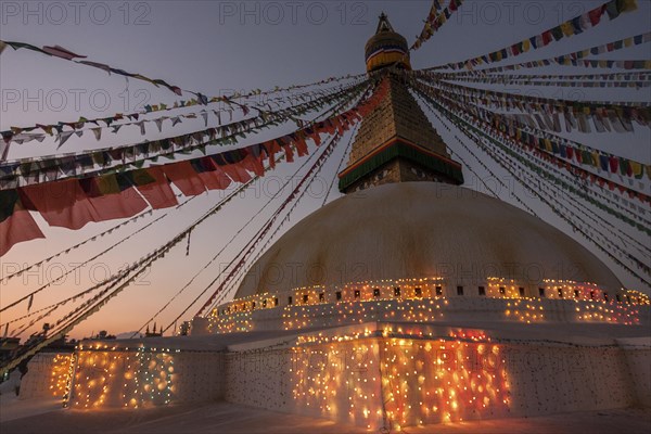 Boudhanath Stupa decorated with prayer flags and lights for the full moon festival