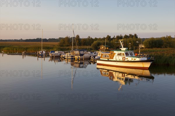 A small motorboat anchored at a landing stage on the Bodden lagoon