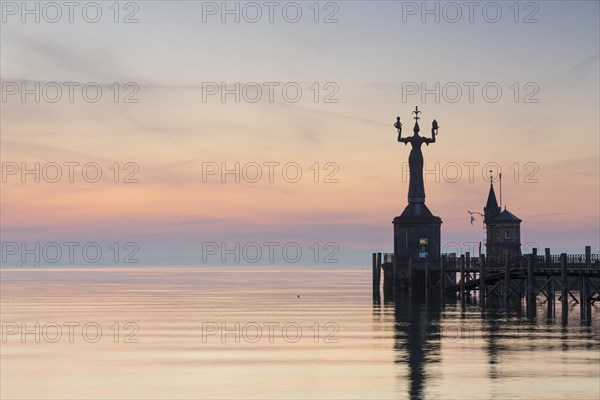 Statue of Imperia at the entrance of the harbour of Konstanz at dawn