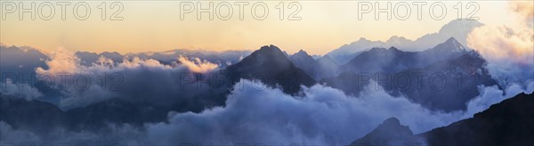 Panorama of the Alps at sunset in the fog