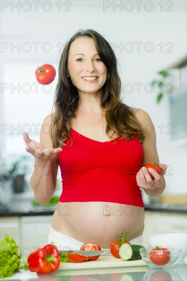Pregnant woman posing with vegetables