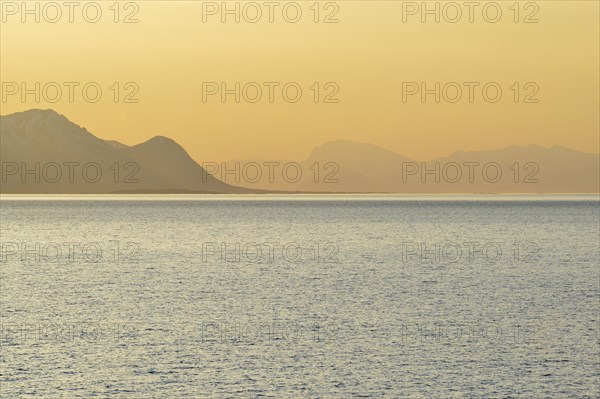 Sunset in the fjord with mountains in the mist