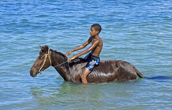 Boy on horseback in the sea