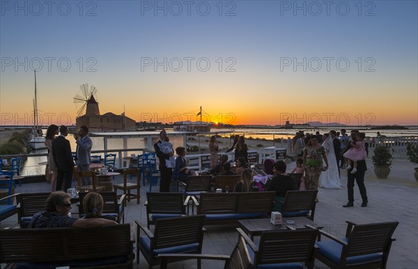 People on the evening in front of the salt pans Ettore Infersa wind mill with salt museum