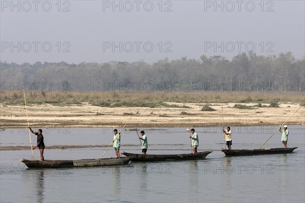 Nepalese men in dugouts on the East Rapti River at Sauraha