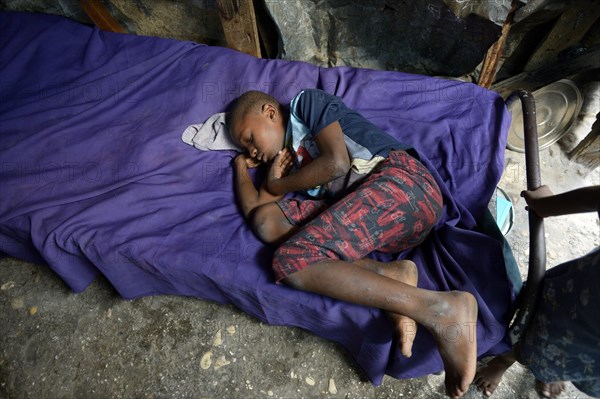 Boy is sleeping on a bed in barracks