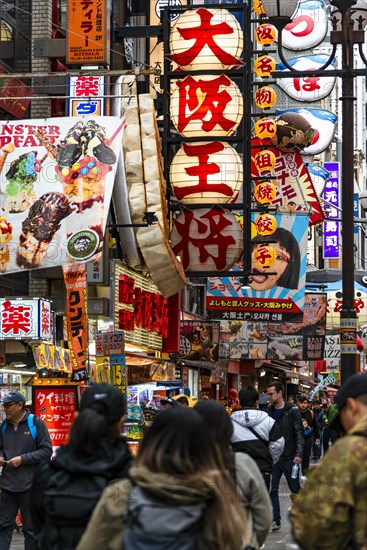 Crowd crowded in pedestrian zone with lots of advertising signs for restaurants and shopping centers
