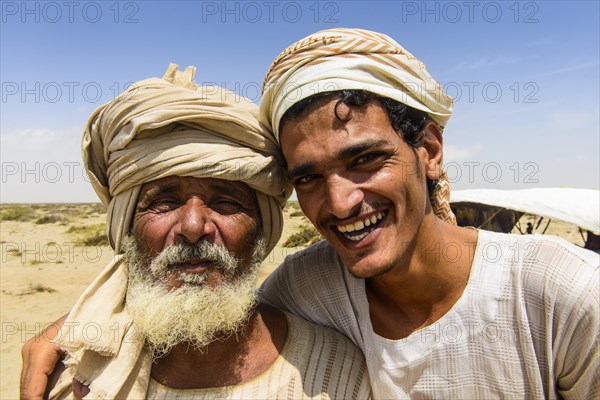 Rashaida father and son standing in front of their tent in the desert around Massaua