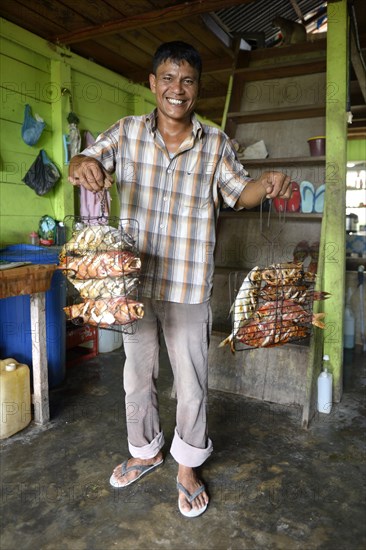 Man presenting grilled fish in restaurant