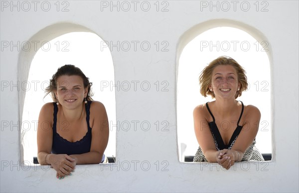 Two young women looking out from the Balcon de Femes