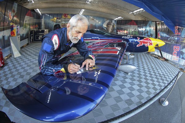Peter Besenyei posing with his plane before the Red Bull Air Race