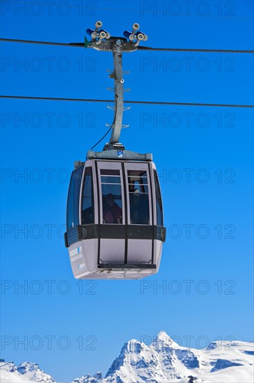 Gondola of the Moosfluh cable car in front of the snowy mountain range of the Valais Alps