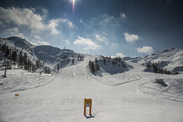 Ski slope with signposts and a few skiers on Gamskogel