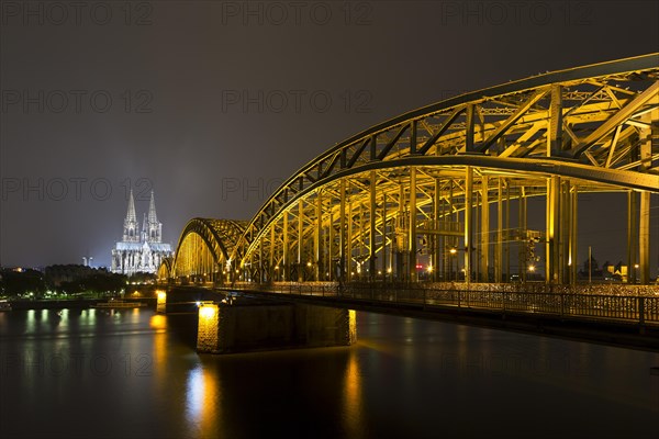 The illuminated Cologne Cathedral and Hohenzollern Bridge at night with Rhine
