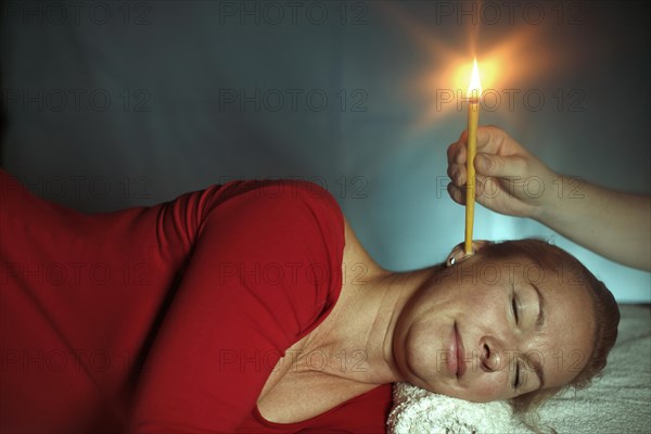 Woman being treated with an ear candle