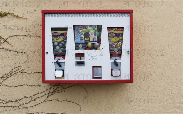 Old chewing gum vending machine on a house wall