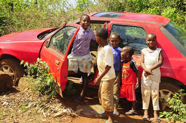 Happy children playing at a car wreck