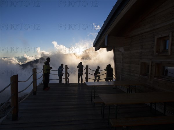 Climbers on the patio of Mantova Hut at sunset