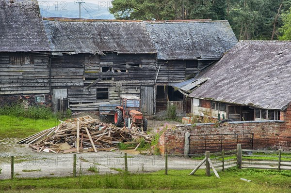 Derelict farmyard with old farm buildings and tractor