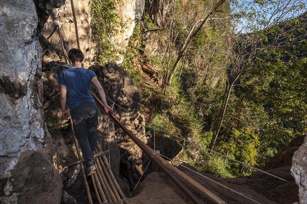 Woman walking on a bamboo bridge