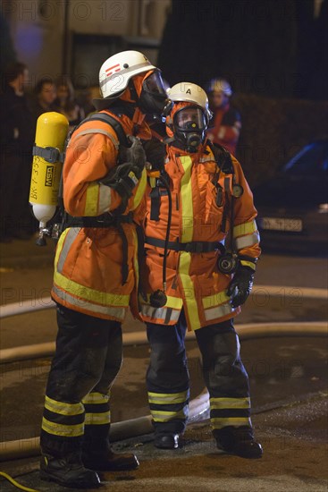 Two firefighters on site at an apartment fire