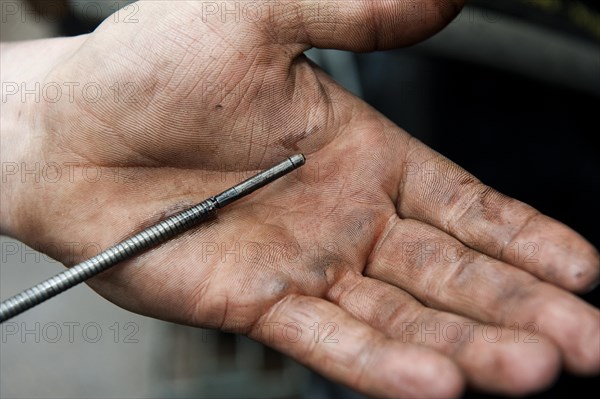 Checking oil level in tractor engine using dipstick