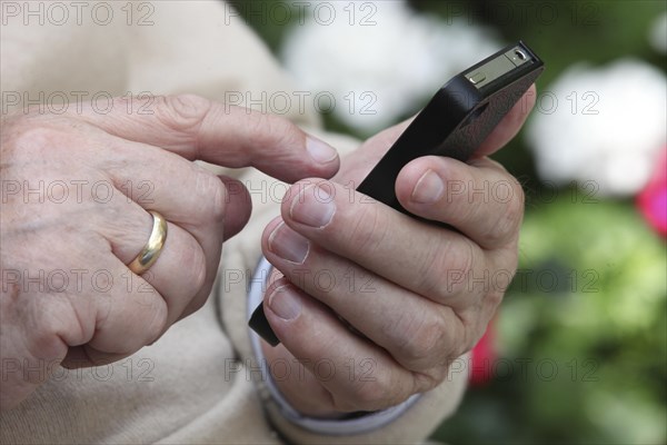 Elderly man holding a smartphone in his hand