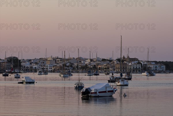 Sailing boats in a harbour at sunset