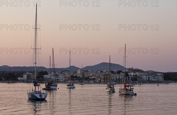 Sailing boats in a harbour at sunset