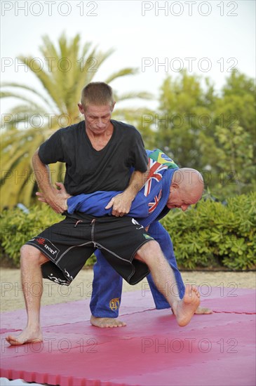 Two men doing martial arts training in a park