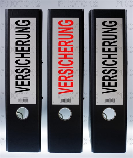 Three ring binders labelled 'VERSICHERUNG'