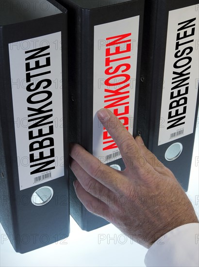 Hand reaching for a file folder labeled "Nebenkosten"