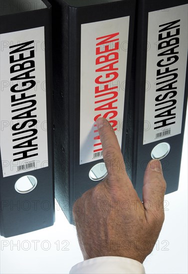 Hand pointing to a file folder labeled 'Hausaufgaben'