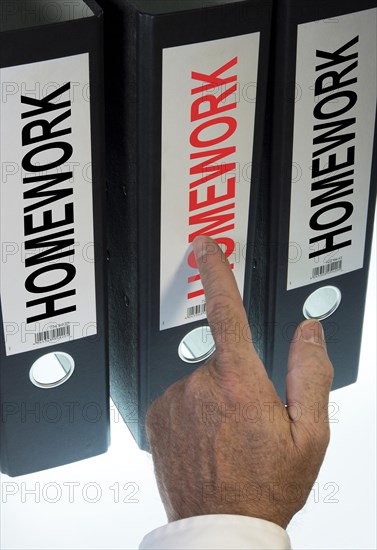 Hand pointing to a file folder labeled 'Homework'