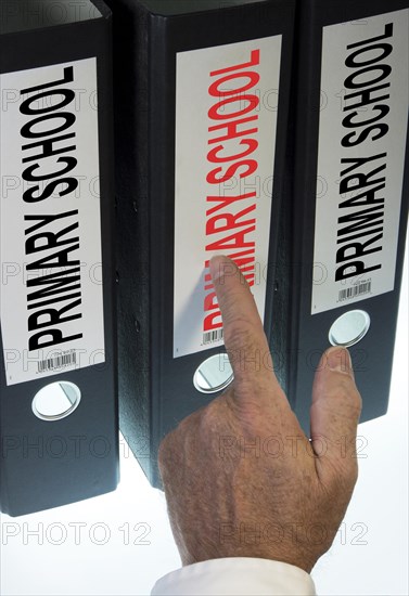 Hand pointing to a file folder labeled 'Primary School'