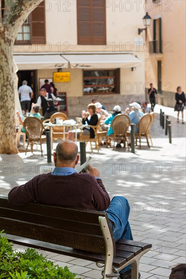 Spaniard reading a newspaper on Plaça de Santa Eulalia square